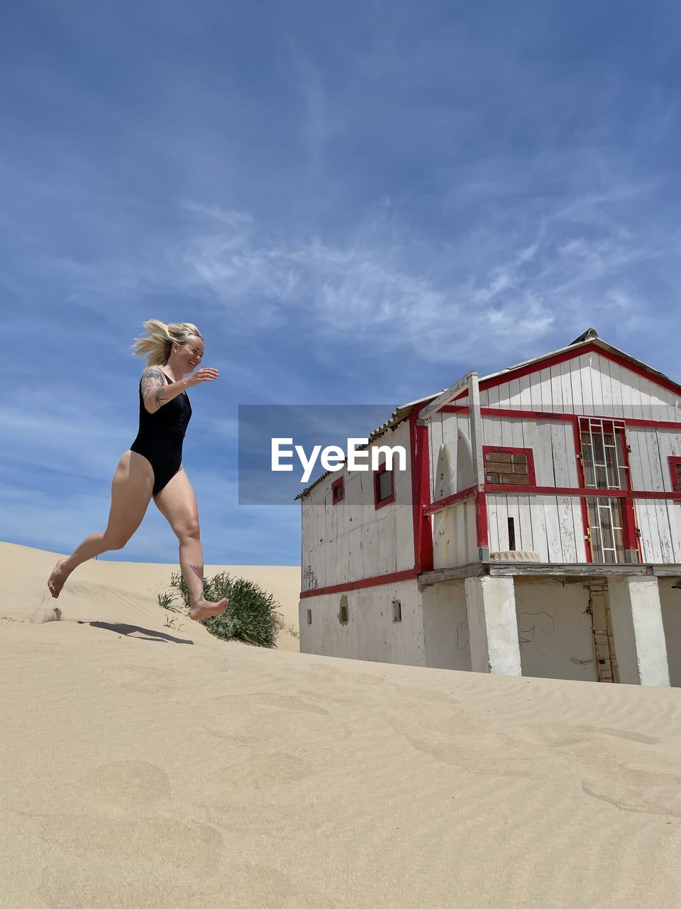 Full length woman running on the sand on the beach