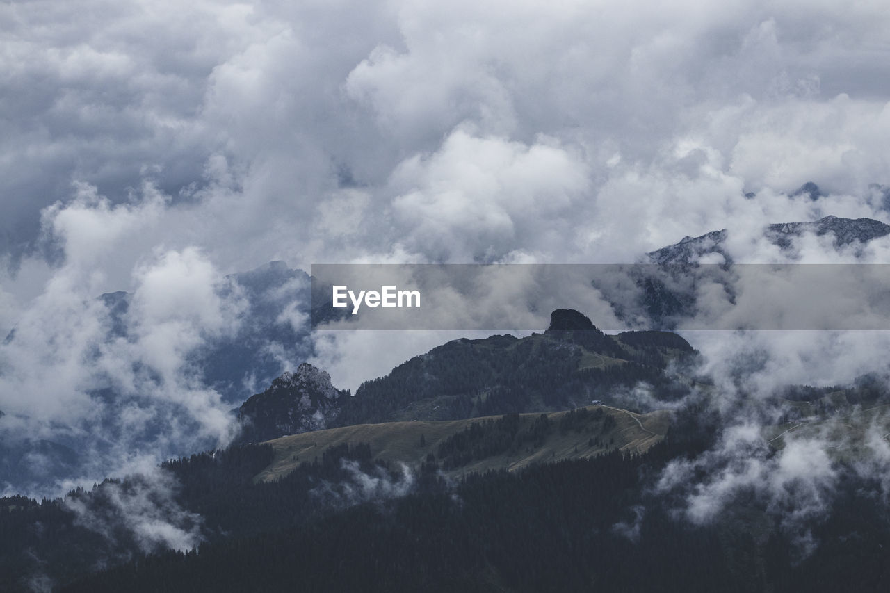 Low angle view of clouds over mountain against sky