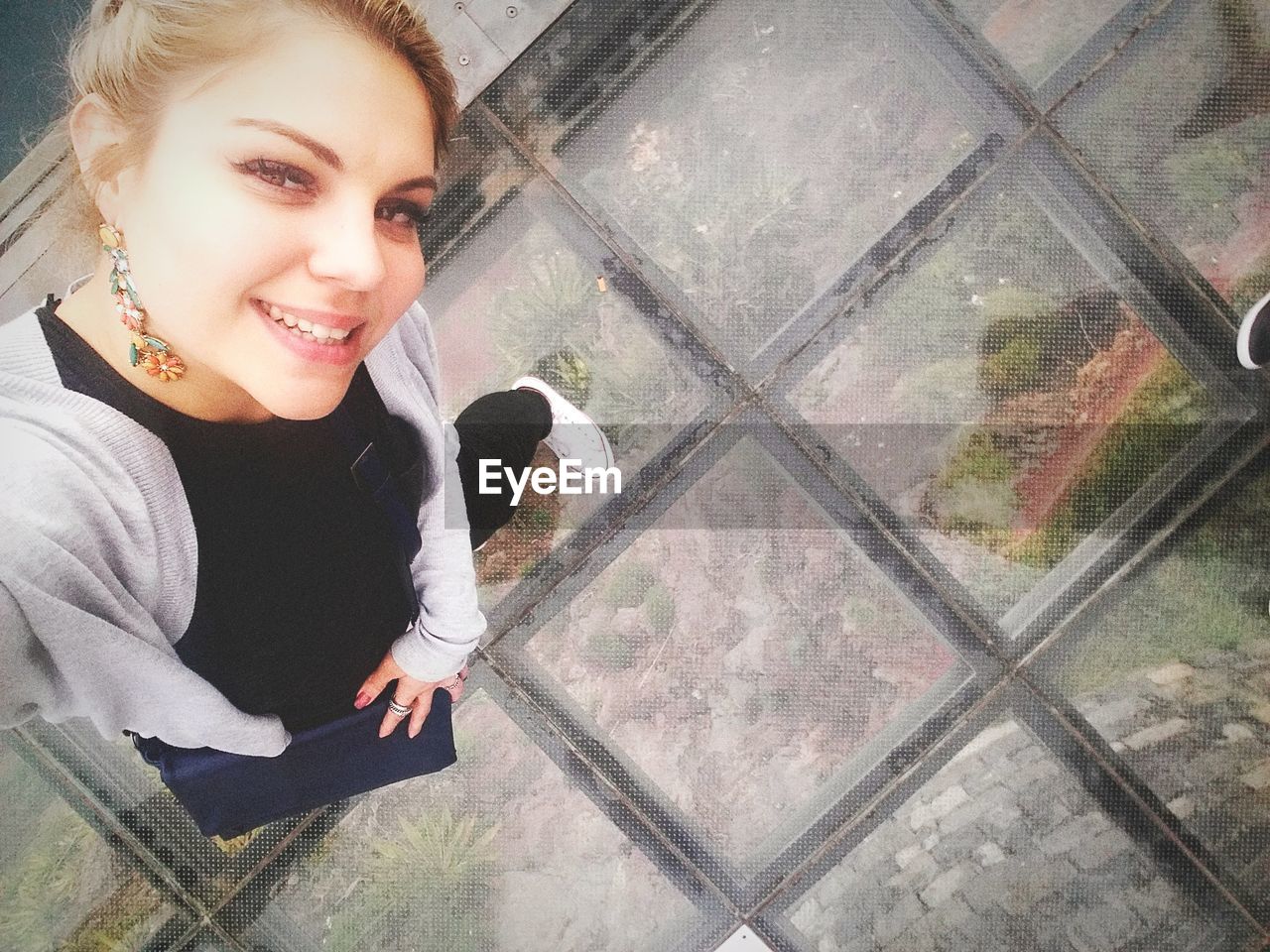 Directly above portrait of woman standing on footpath