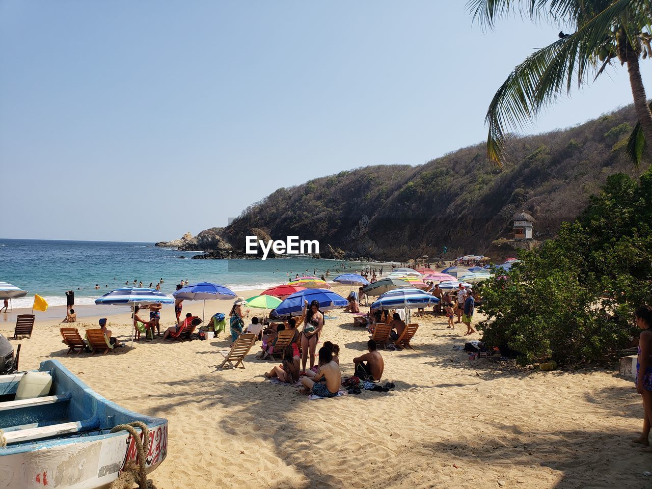 PEOPLE AT BEACH AGAINST CLEAR SKY