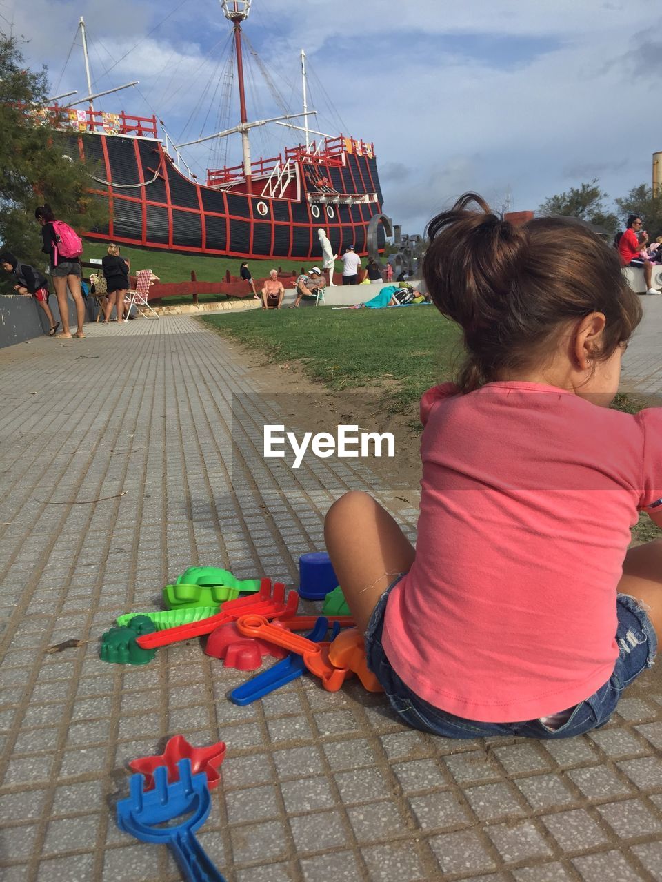 REAR VIEW OF WOMEN SITTING ON TOY AT FARM