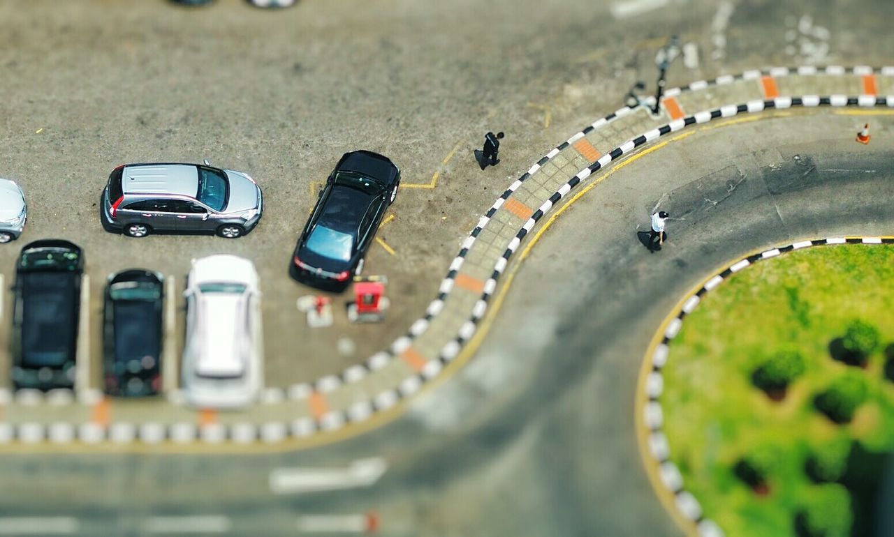 Tilt-shift image of parking lot by street