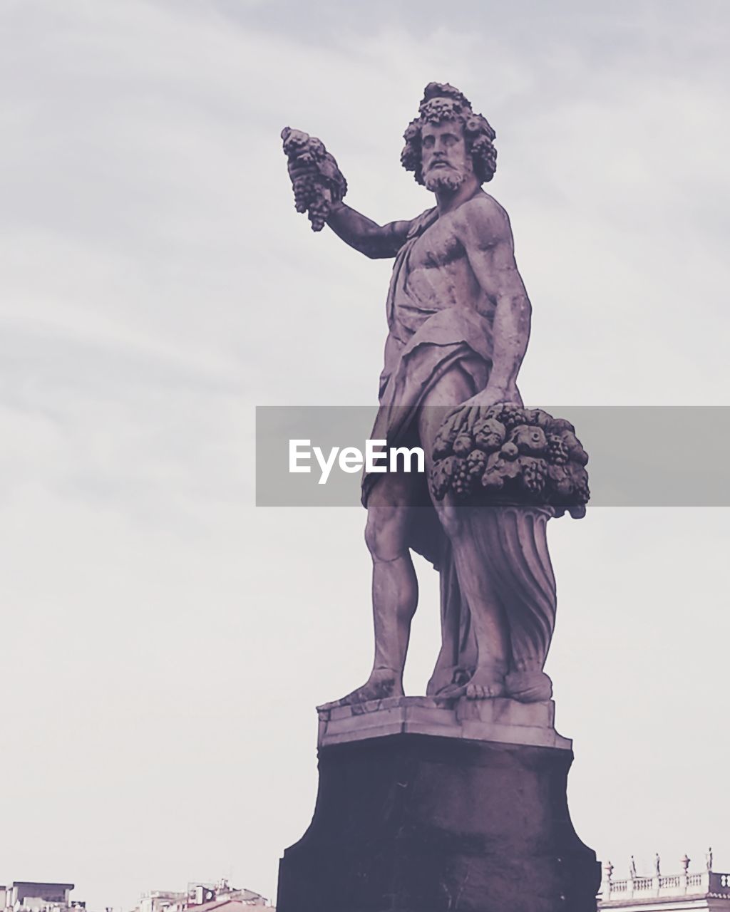 LOW ANGLE VIEW OF STATUE IN CITY AGAINST CLOUDY SKY