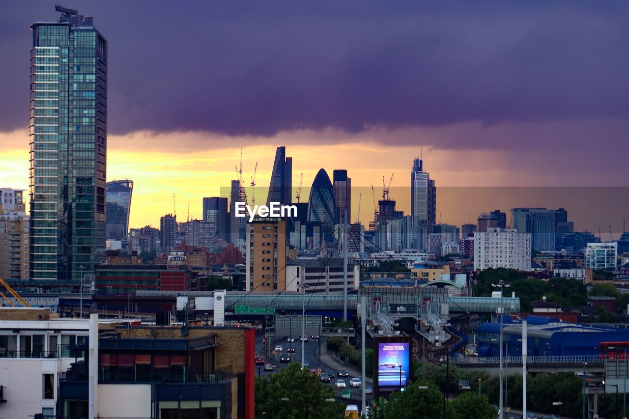 View of cityscape against cloudy sky during sunset