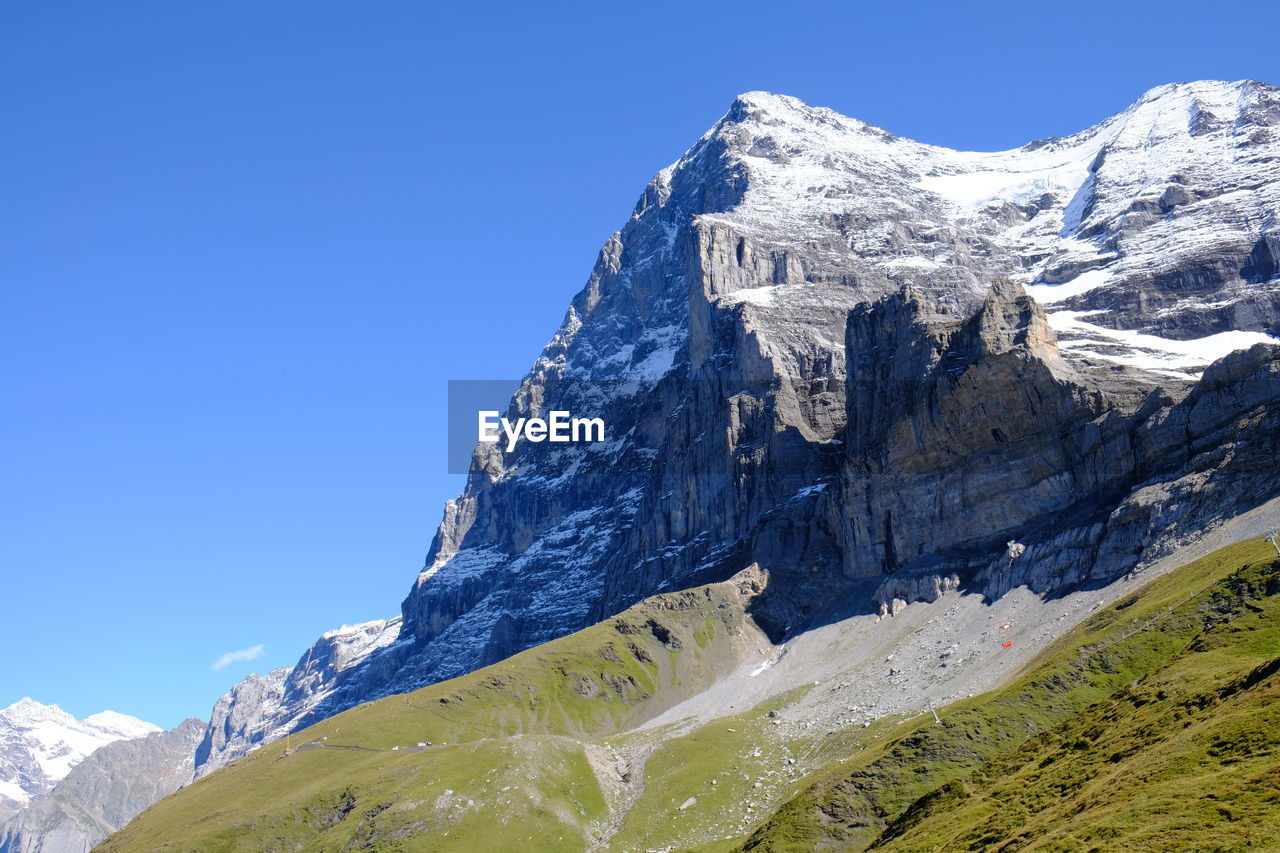 Scenic view of snowcapped mountains against clear blue sky