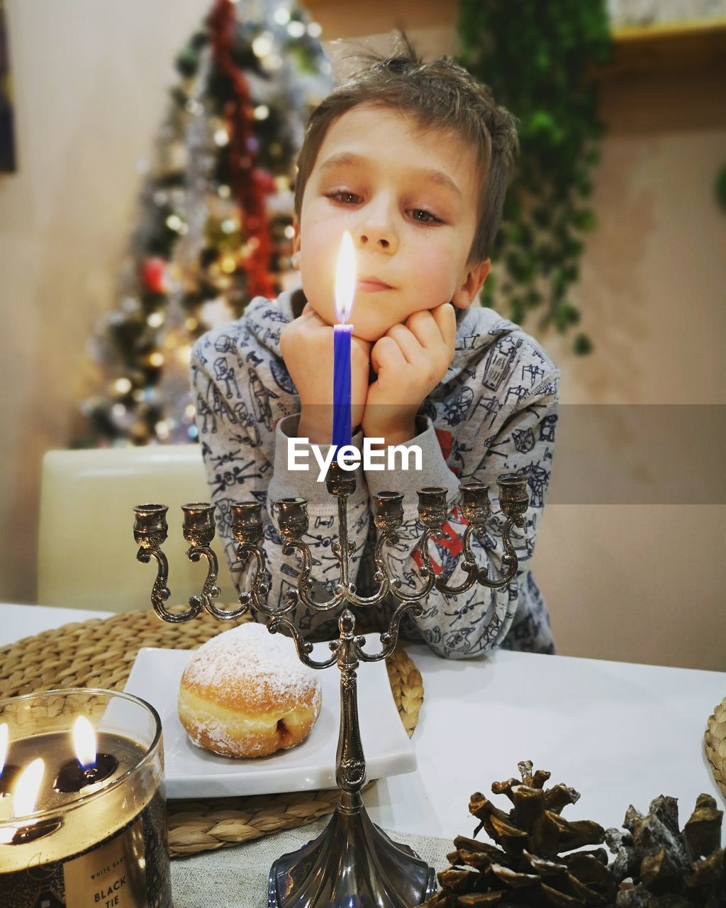 Portrait of young boy with menorah at the beginning of hanukkah. 