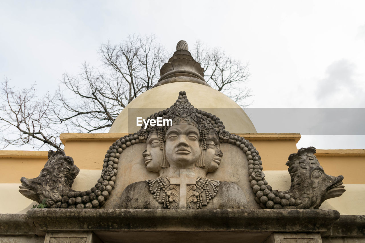 LOW ANGLE VIEW OF STATUE AGAINST TEMPLE BUILDING