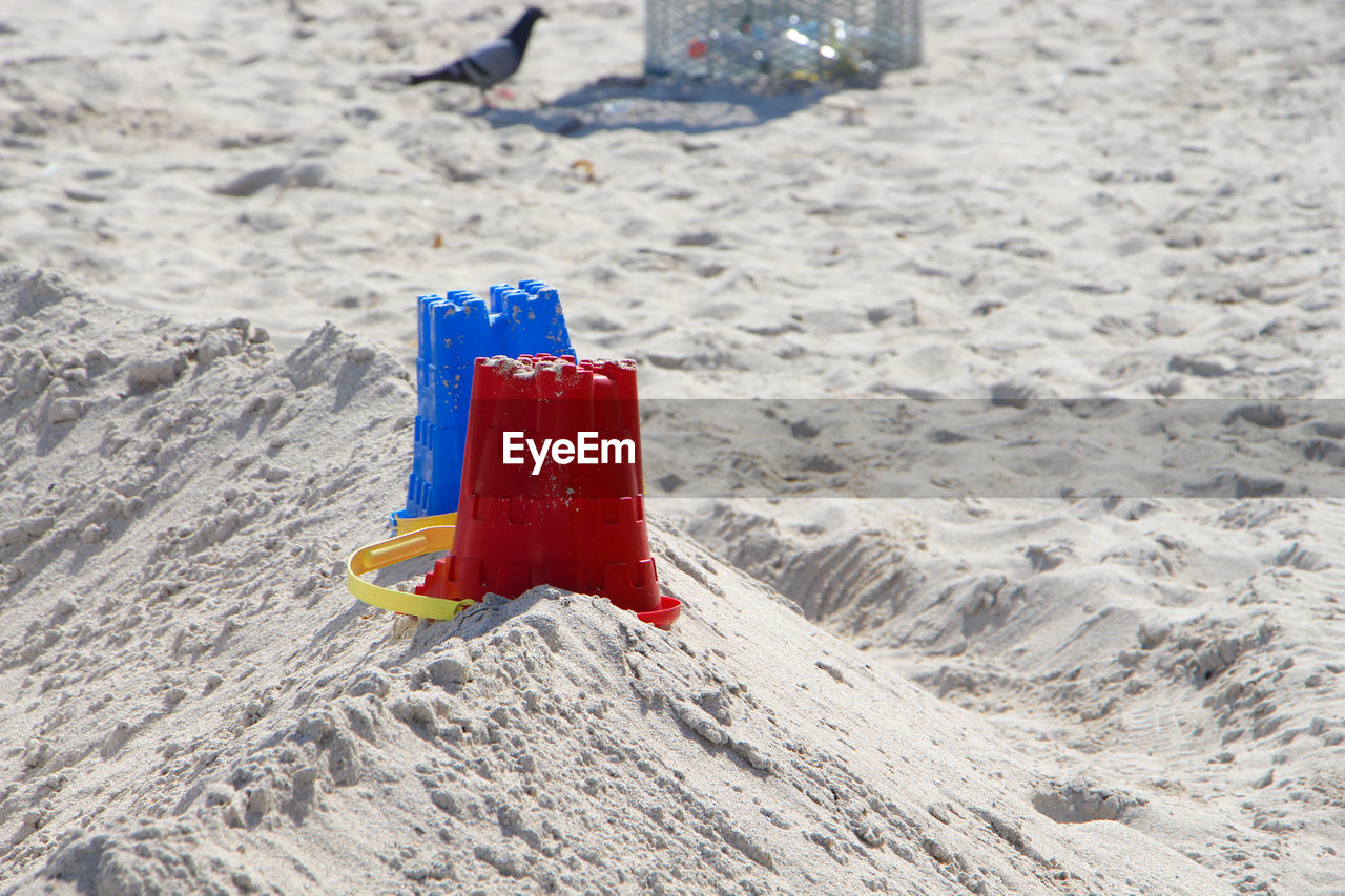 High angle view of upside down buckets on sand at beach