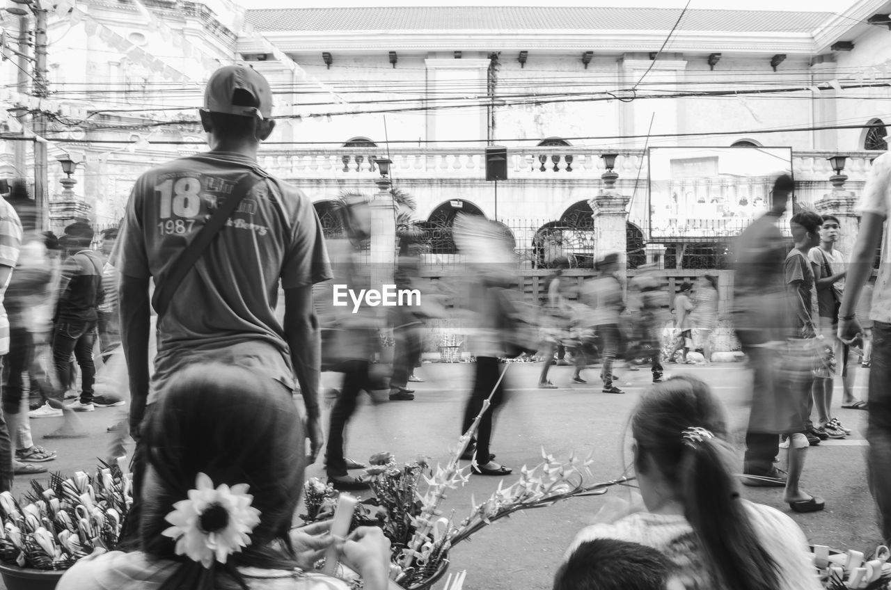 REAR VIEW OF PEOPLE ON CITY STREET