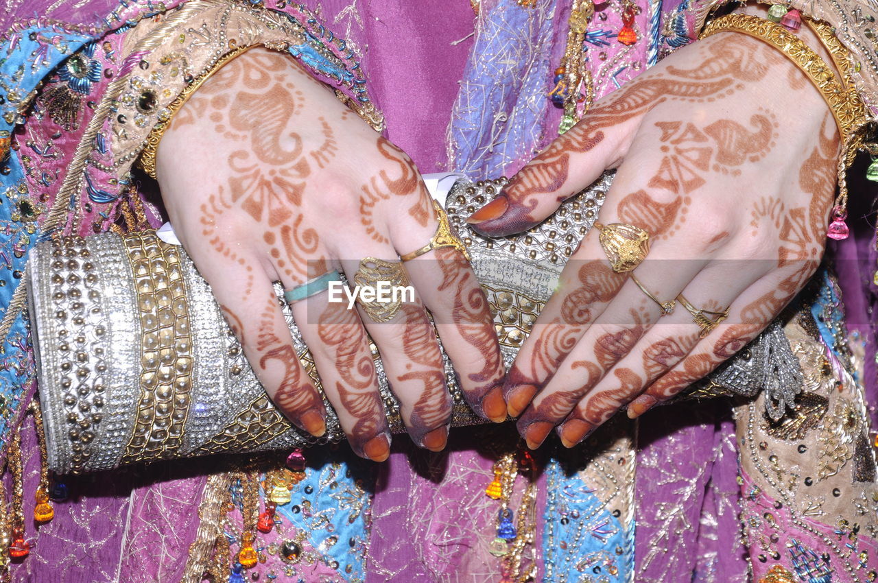 Midsection of bride in sari holding purse