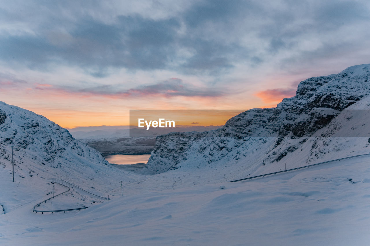 Snow covered mountains against sky during sunset