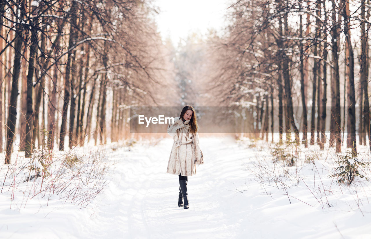 FULL LENGTH OF WOMAN STANDING ON SNOW