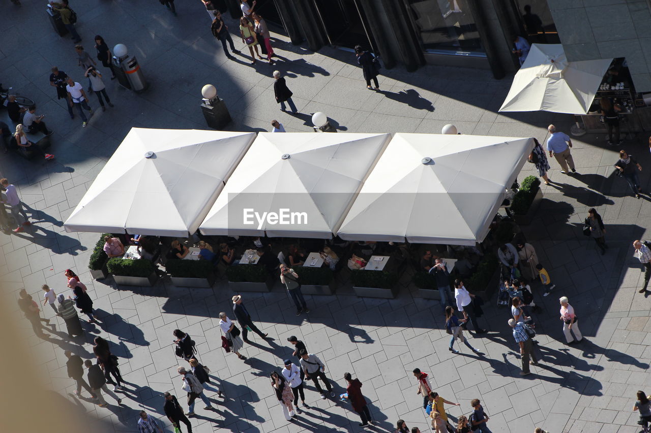 HIGH ANGLE VIEW OF PEOPLE ON CITY STREET