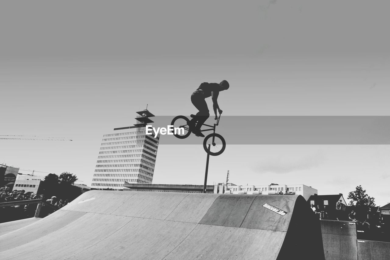 low angle view of man walking on street against sky