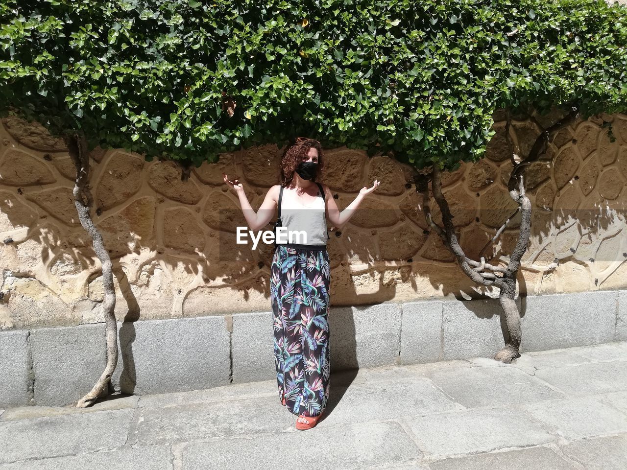 Full length of woman standing against wall