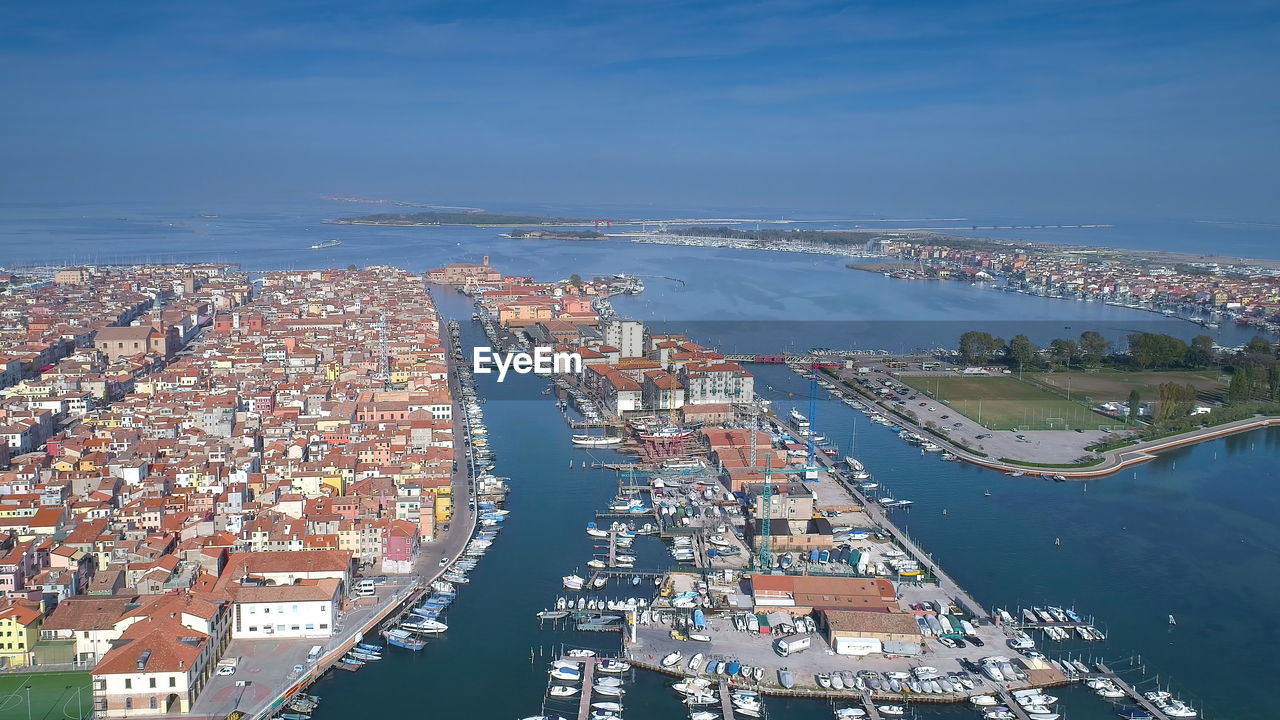 High angle view of buildings by sea against sky