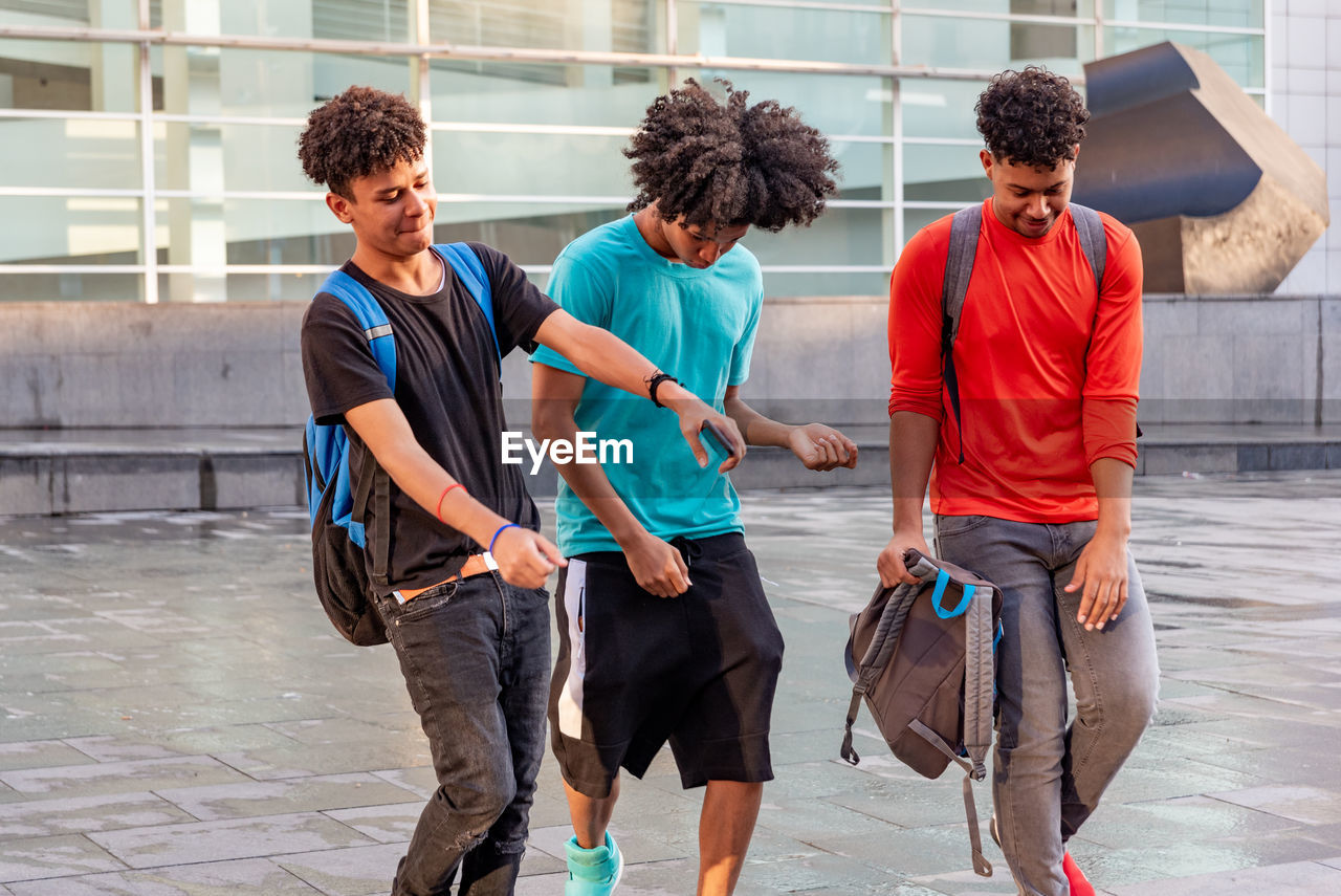 Group of afro latin male friends dancing in the street