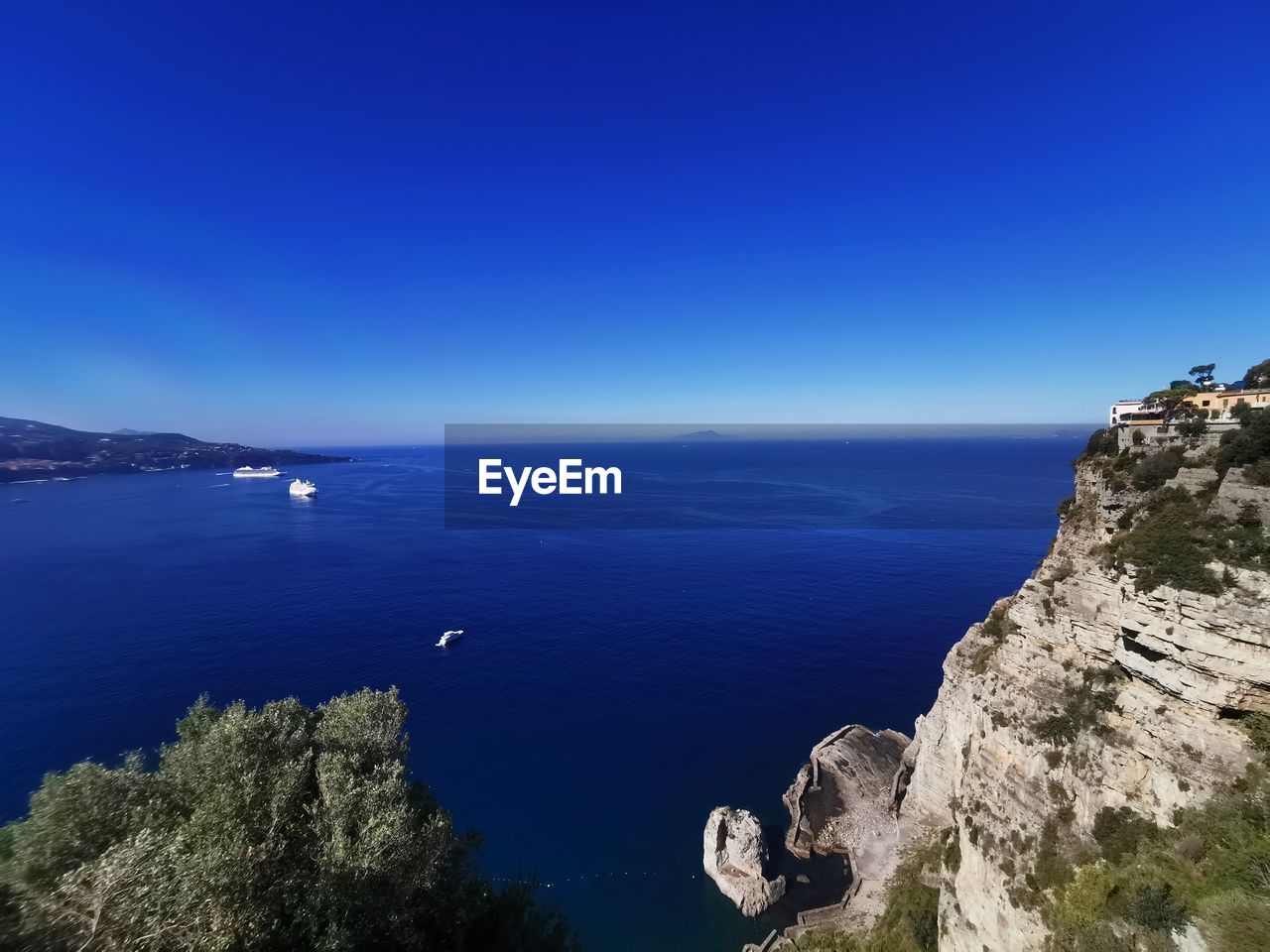 Scenic view of sea against clear blue sky