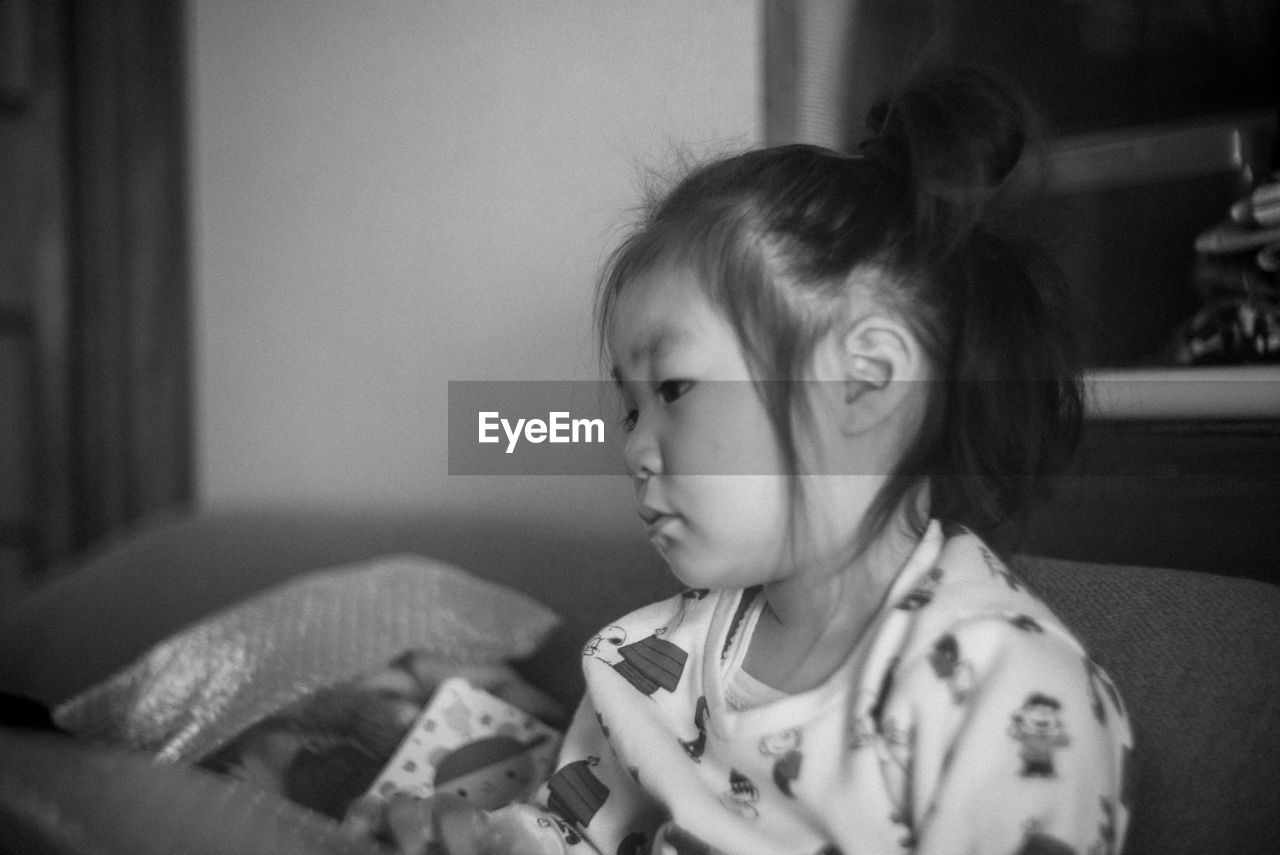 childhood, child, indoors, black, one person, person, white, baby, portrait, black and white, home interior, female, domestic room, innocence, monochrome photography, furniture, women, sitting, monochrome, emotion, toddler, lifestyles, headshot, looking, cute, human face, domestic life, casual clothing, sofa, portrait photography, focus on foreground