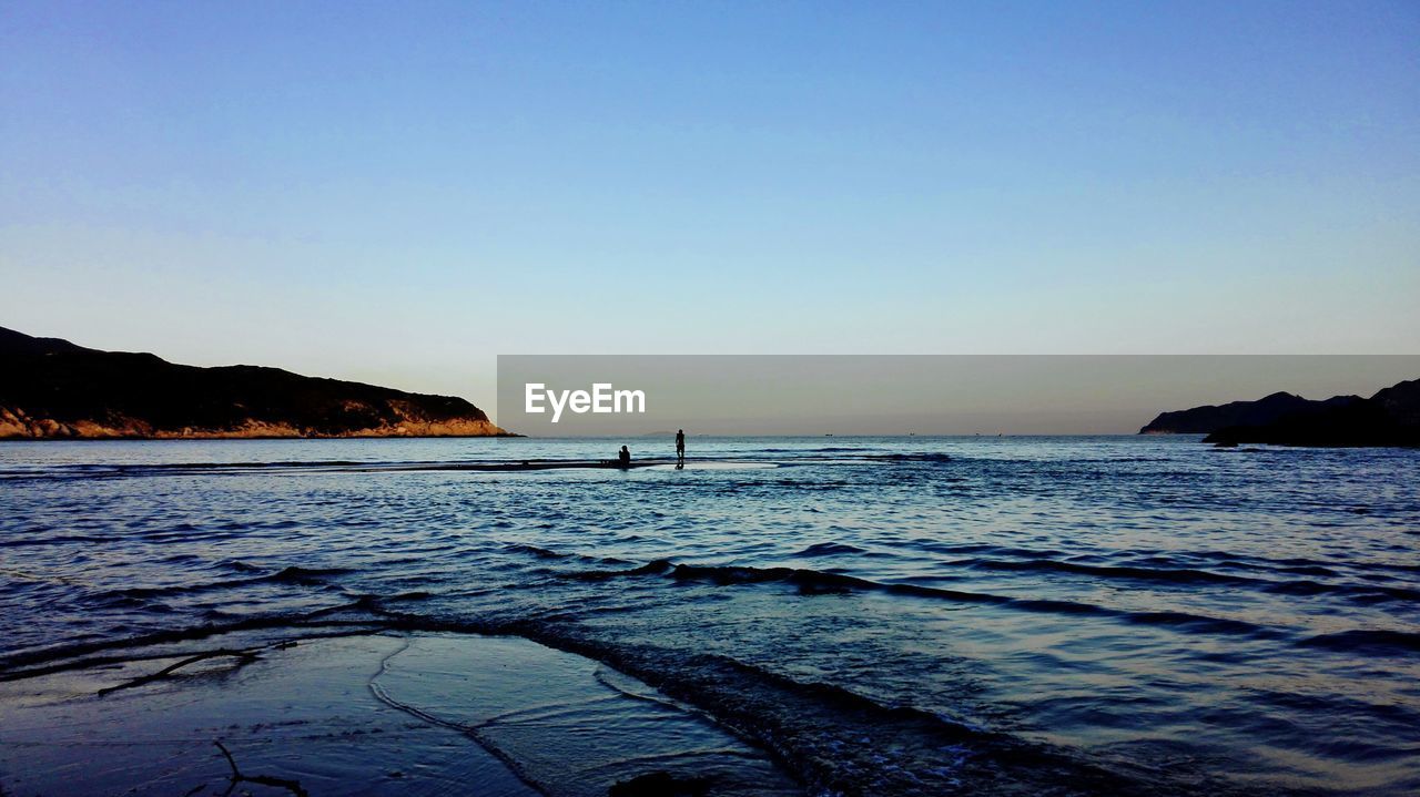 SCENIC VIEW OF SEA AGAINST CLEAR SKY DURING SUNSET