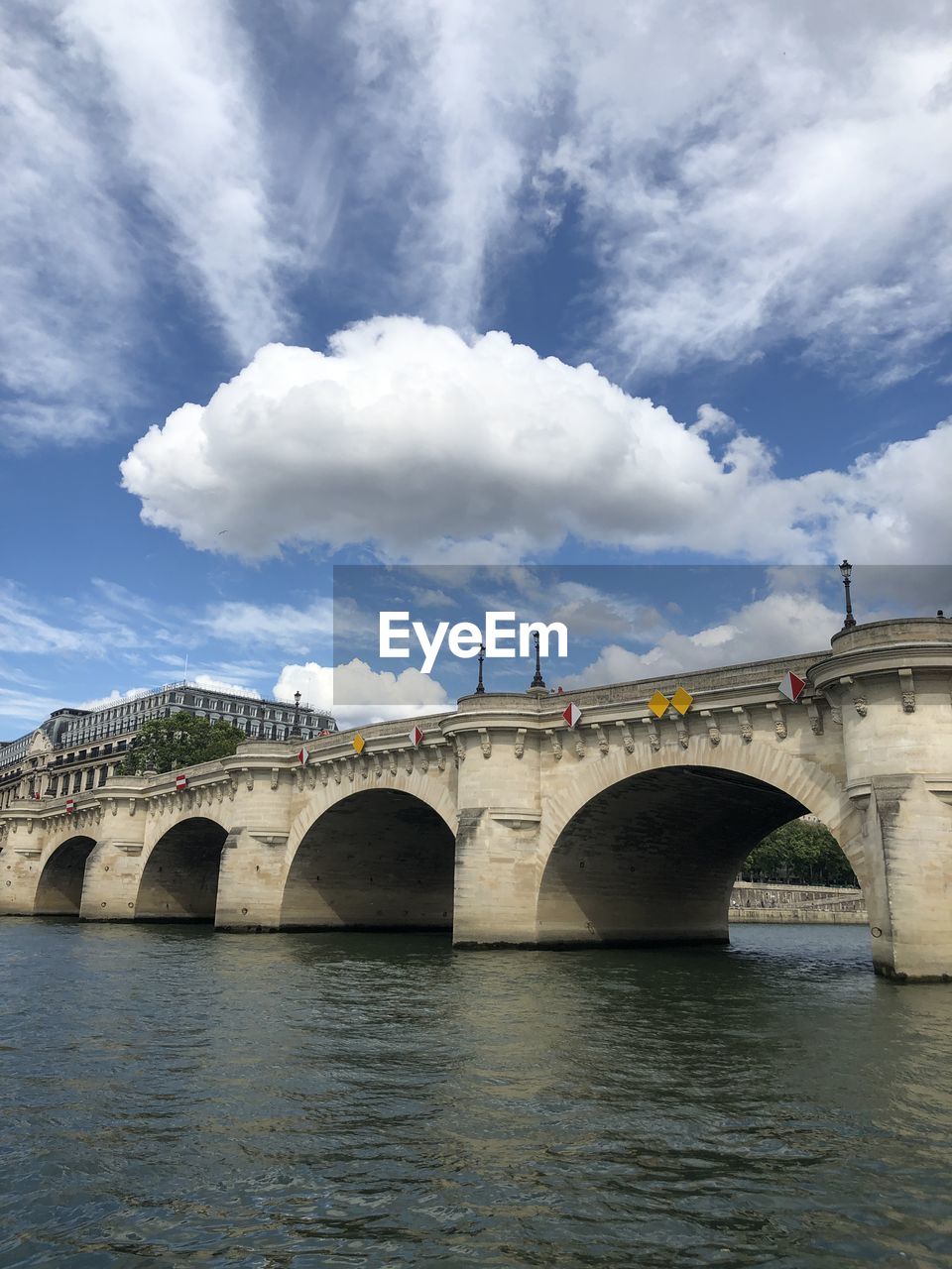 Arch bridge over river against cloudy sky