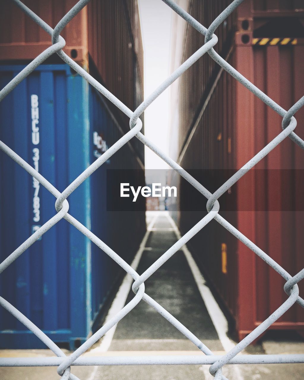 Cargo containers seen through chainlink fence