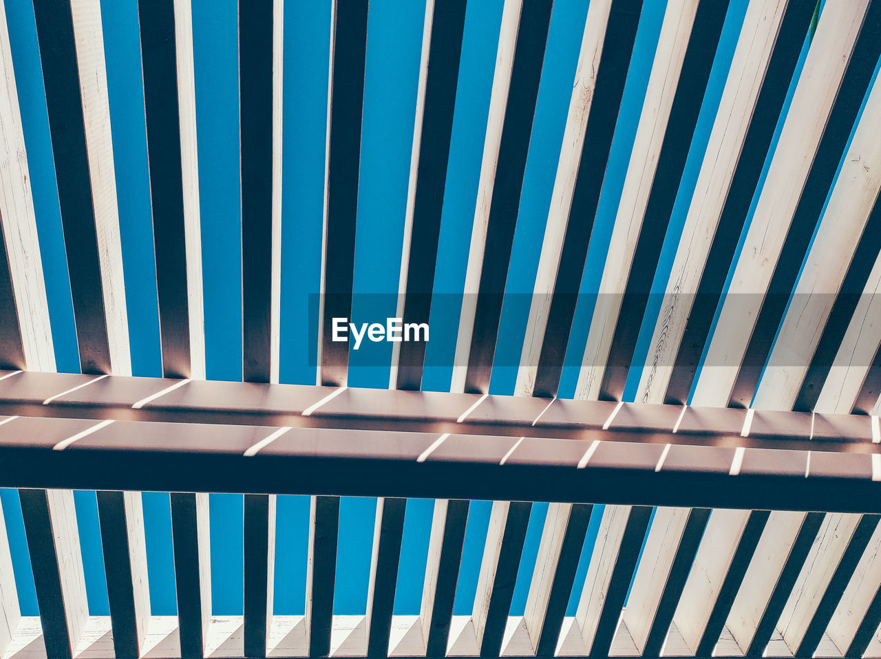 Low angle view of railing against blue sky