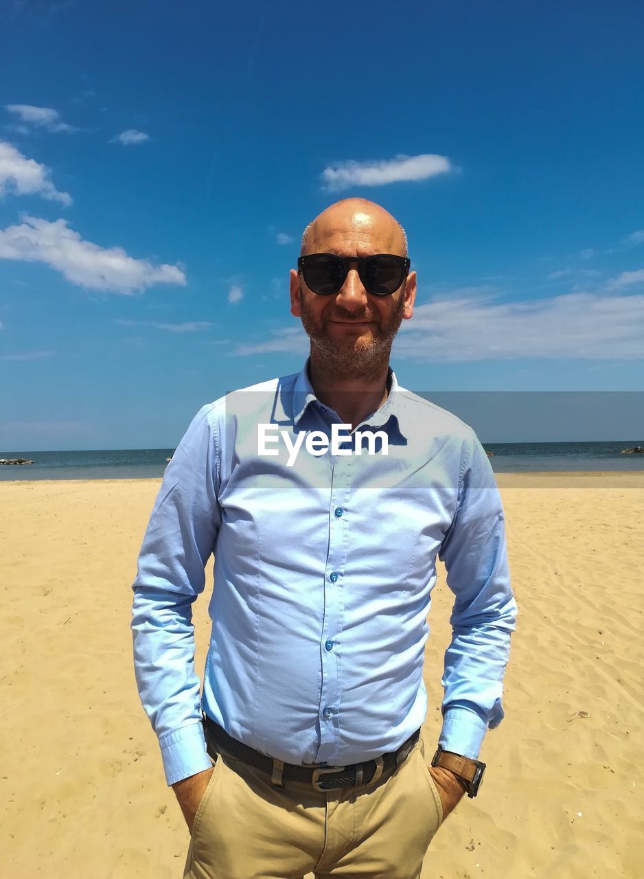 Man wearing sunglasses standing on beach