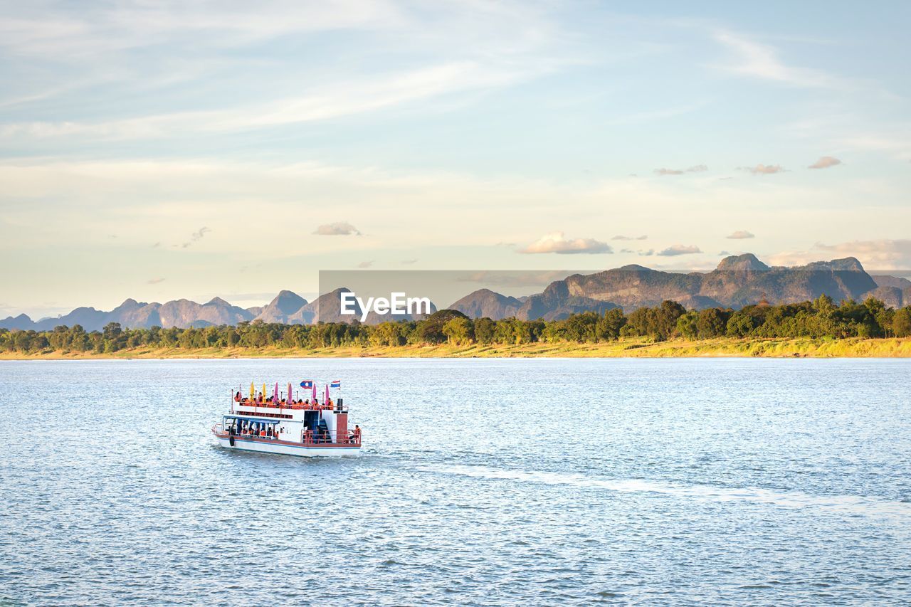 Ferry boat in lake against sky