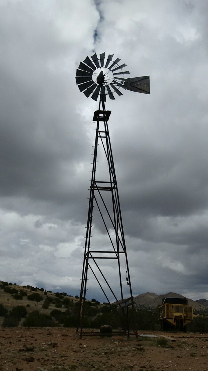 Low angle view of windmill against clouds