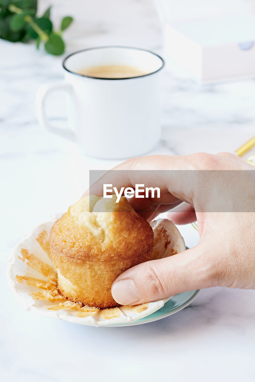 Woman's hand grabbing a homemade muffin.