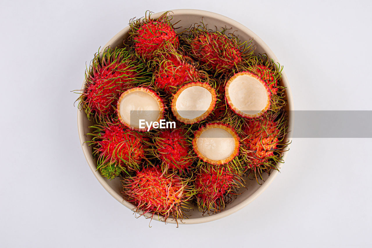 Rambutan fruits in white plate on white background, top view.,close-up