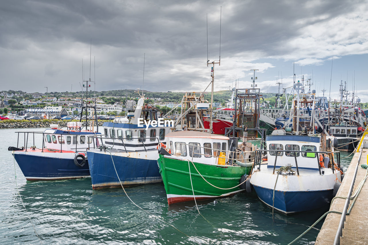 Four small fishing boats moored in howth harbour, dublin, ireland