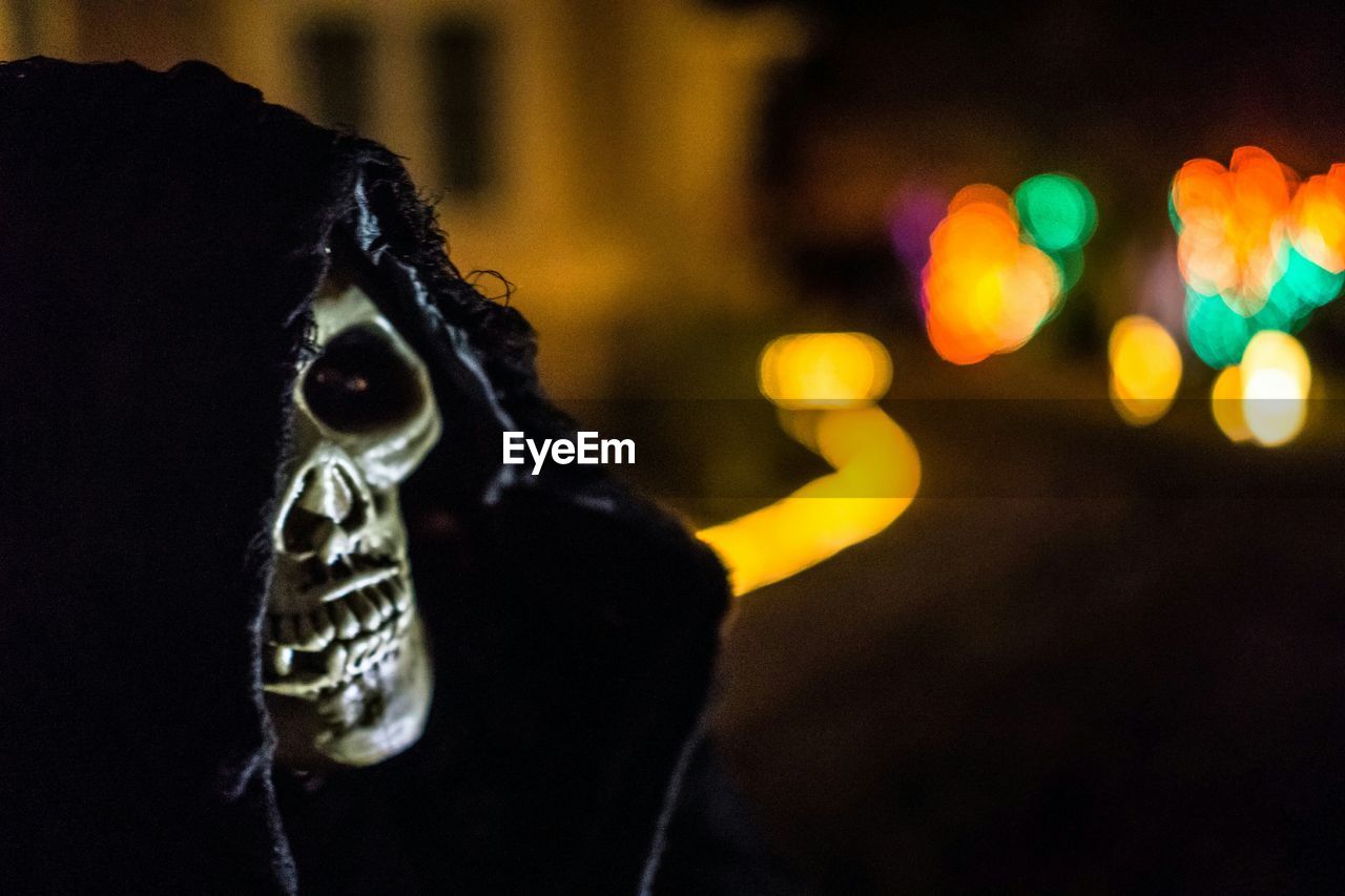 Close-up of human skull wrapped in fabric during halloween at night