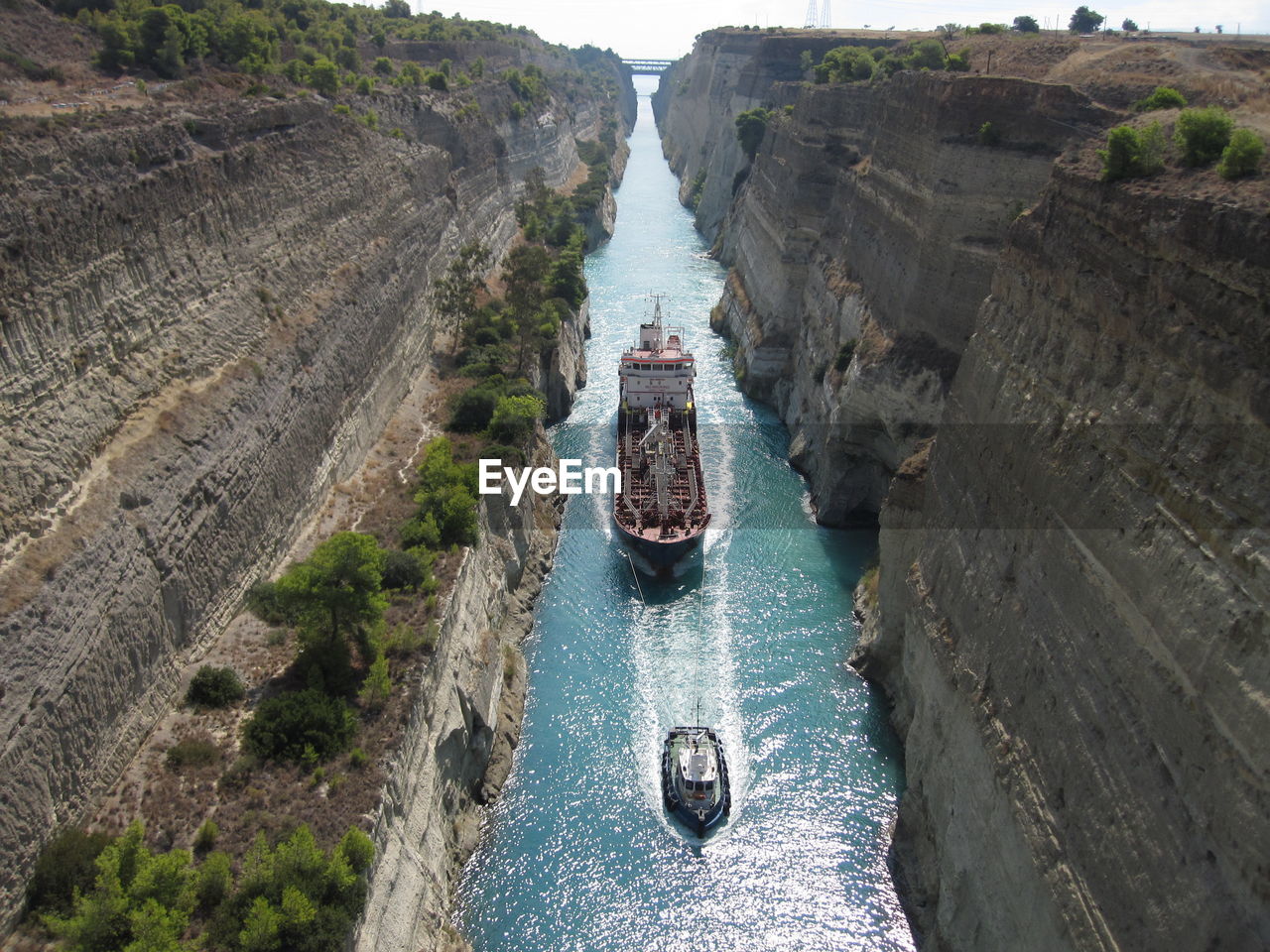 High angle view of cargo ship and trawler in canal