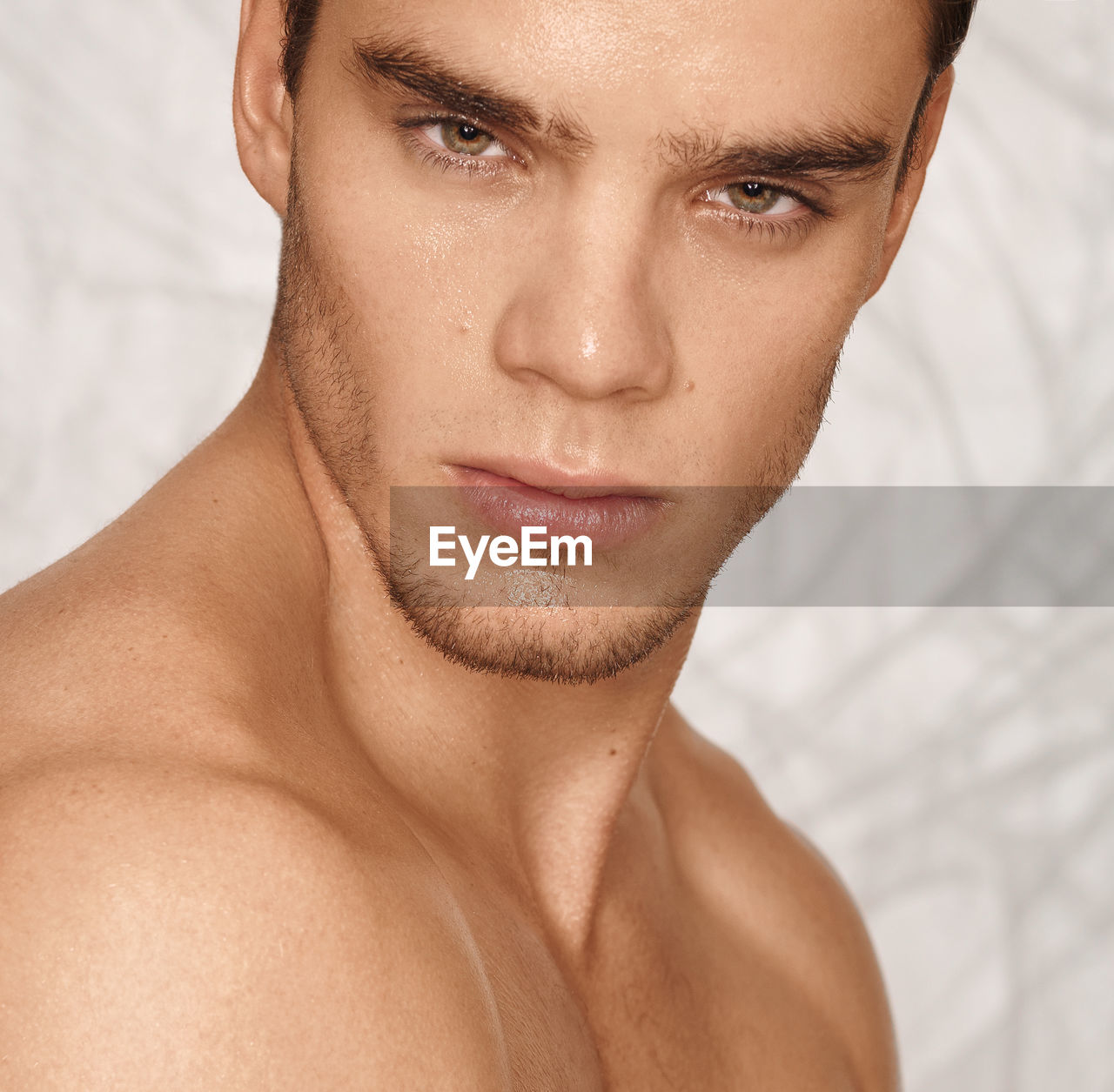 Close-up portrait of shirtless young man