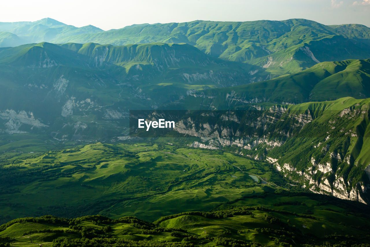 SCENIC VIEW OF MOUNTAINS AGAINST GREEN LANDSCAPE