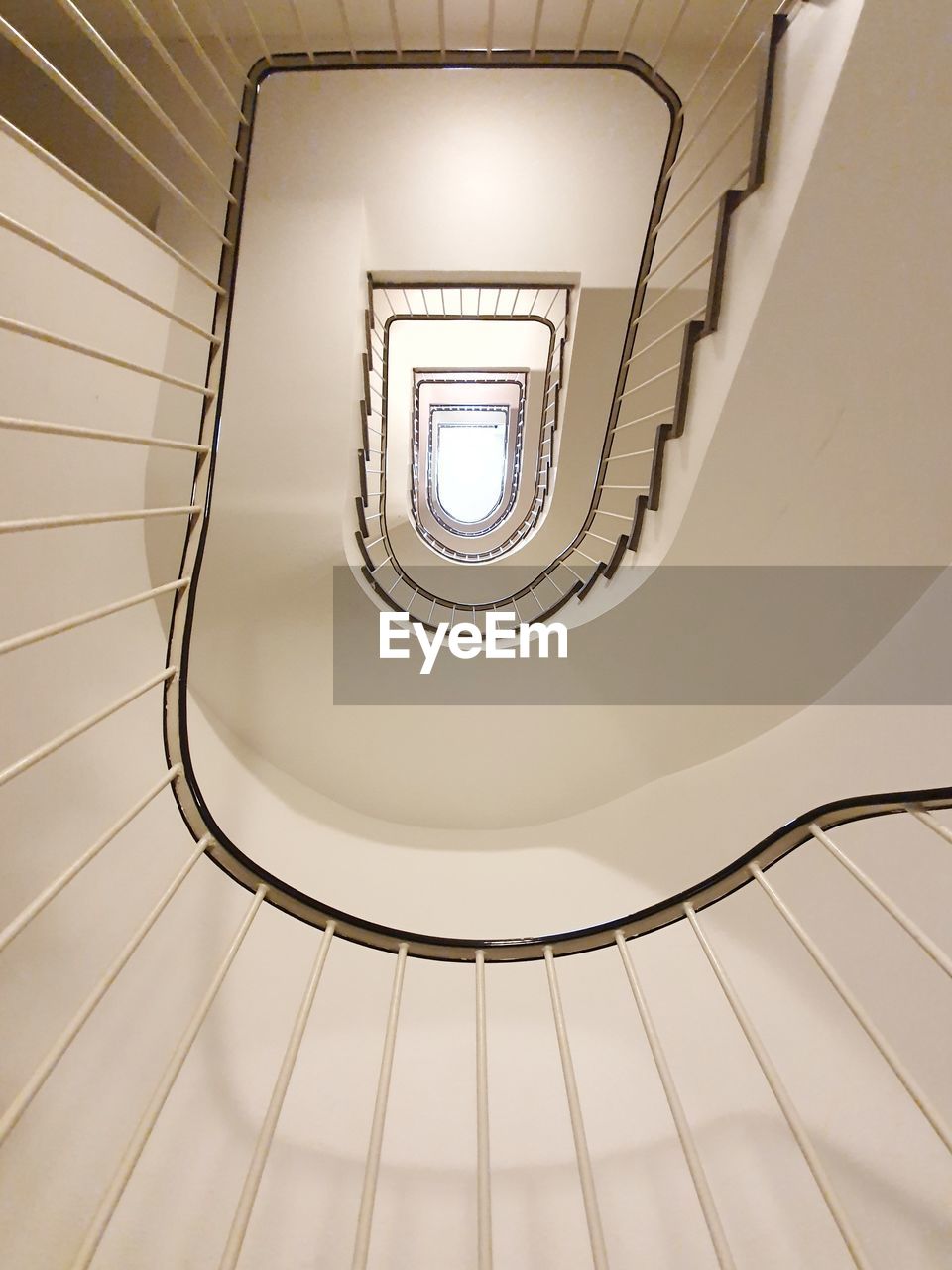 DIRECTLY BELOW SHOT OF SPIRAL STAIRCASE IN BUILDING