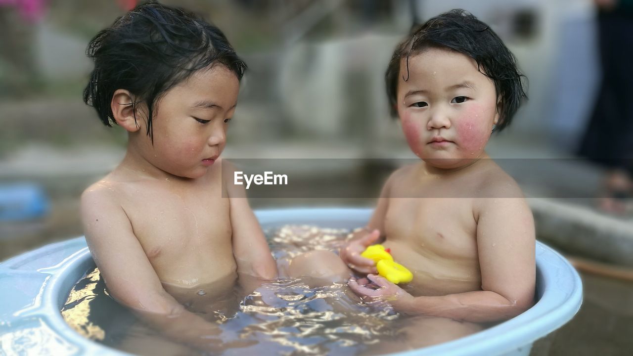 Close-up of two children taking a bath