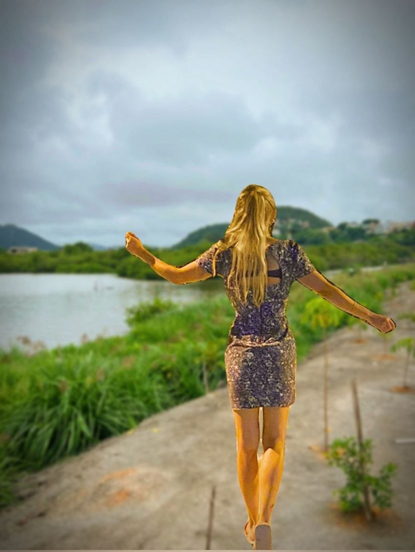 one person, women, adult, full length, water, long hair, hairstyle, nature, young adult, rear view, limb, clothing, sky, cloud, arm, arms outstretched, blond hair, dress, fashion, standing, human limb, leisure activity, outdoors, day, sea, lifestyles, casual clothing, carefree, beauty in nature, trip, vacation, holiday, environment, walking, plant, travel, brown hair, motion, yellow, travel destinations, emotion, summer, happiness, female, land, arms raised, beach