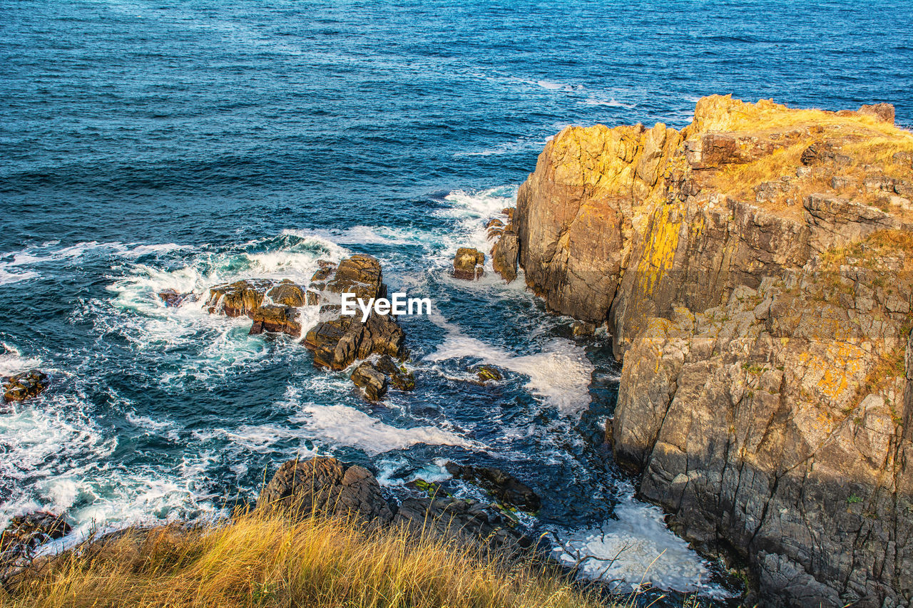 HIGH ANGLE VIEW OF ROCKS ON SEA