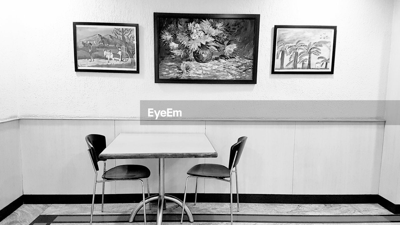 EMPTY CHAIRS AND TABLES AGAINST WALL