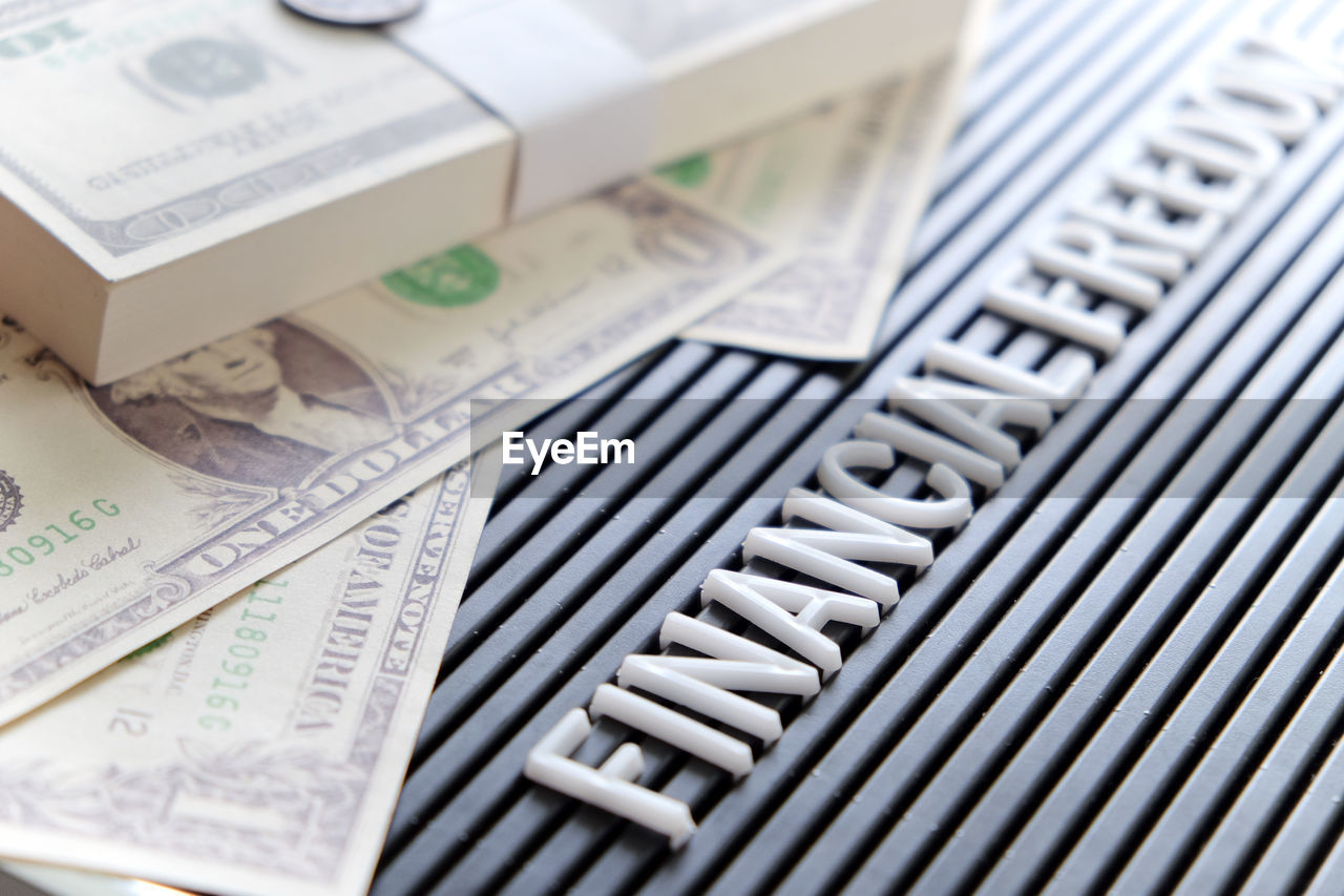 Close-up of text with money on table