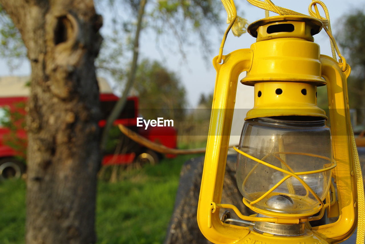 Old yellow petrol lamp with a garden in the background - photo was taken in 2018