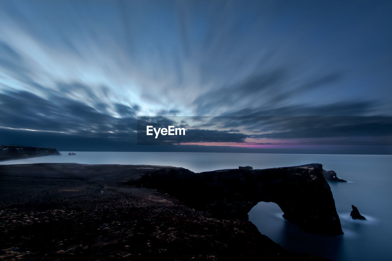 Scenic view of sea against sky dyrhólaey rock formation at sunrise 