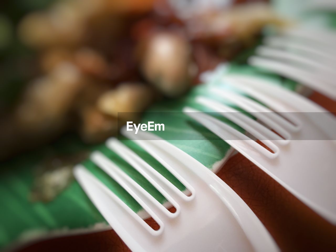 Close-up of white plastic forks by food