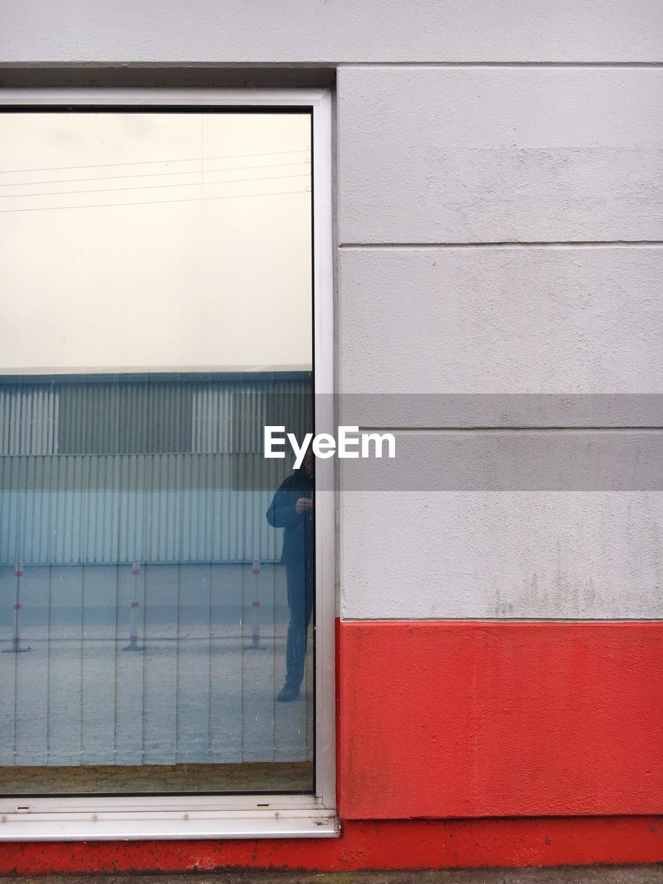 Cropped image of man reflecting on window glass