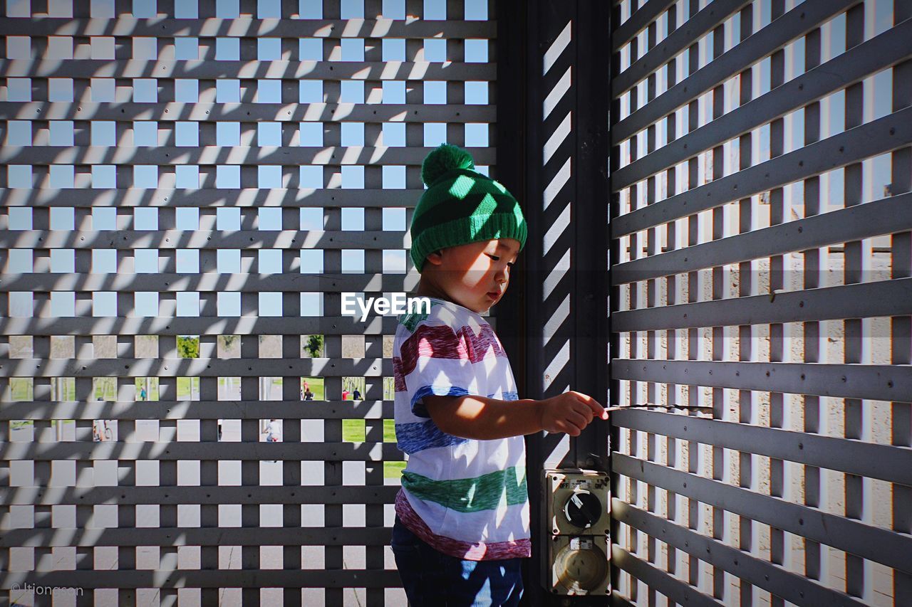 Side view of a boy looking through window