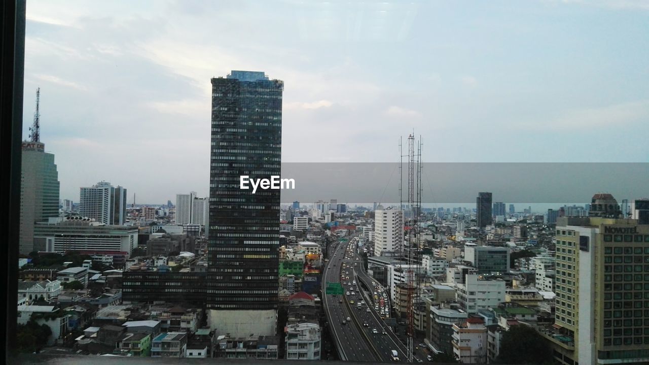 HIGH ANGLE VIEW OF BUILDINGS AGAINST SKY IN CITY