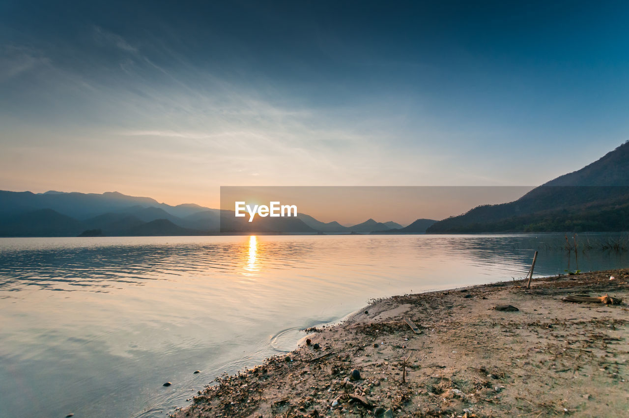 Scenic view of lake against sky during sunset